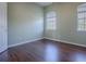 Bedroom featuring hardwood floors, neutral green walls, and two large windows with blinds at 16126 Bristol Lake Cir, Orlando, FL 32828