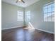 Well-lit bedroom with hardwood floors, three large windows, and soothing light green walls at 16126 Bristol Lake Cir, Orlando, FL 32828