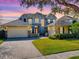 Two-story home boasting a manicured lawn, multi-car garage, stone accents, and a welcoming front facade at 16126 Bristol Lake Cir, Orlando, FL 32828