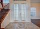 Bright foyer featuring double doors, a staircase with iron railing, tile floors, and natural light at 16126 Bristol Lake Cir, Orlando, FL 32828