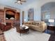 Cozy living room with custom wood shelving, a couch and a round coffee table at 16126 Bristol Lake Cir, Orlando, FL 32828