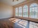 Bright living room featuring three arched windows overlooking the water and hardwood floors at 16126 Bristol Lake Cir, Orlando, FL 32828