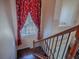 Staircase with hardwood floors, metal rails and red curtains at 16126 Bristol Lake Cir, Orlando, FL 32828