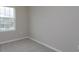 A clean bedroom features neutral walls and carpet, complemented by a window letting in natural light at 16434 Hamlin Hills Rd, Winter Garden, FL 34787