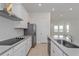 Modern kitchen featuring white cabinetry, stone countertops and stainless steel appliances at 16465 Hamlin View St, Winter Garden, FL 34787