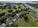 Expansive aerial view showcasing a neighborhood with lush green spaces, ponds, and a glimpse of a lake in the background at 16627 Rockwell Heights Ln, Clermont, FL 34711