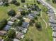 Scenic aerial view of a residential neighborhood featuring mature trees, ponds, and well-maintained lawns at 16627 Rockwell Heights Ln, Clermont, FL 34711