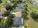 Overhead view of a home with a screened-in pool, surrounded by mature trees and well-manicured lawns at 16627 Rockwell Heights Ln, Clermont, FL 34711