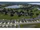 Aerial view of a well-manicured, expansive residential area featuring a lake, lush lawns, and charming single-Gathering homes at 16627 Rockwell Heights Ln, Clermont, FL 34711