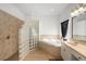 Bright bathroom featuring a soaking tub, glass block shower, and vanity with a cream countertop at 16627 Rockwell Heights Ln, Clermont, FL 34711