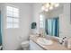 Bright bathroom featuring a sink, toilet, and shower-tub combo with a blue curtain at 16627 Rockwell Heights Ln, Clermont, FL 34711