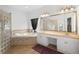 Bright bathroom featuring a large soaking tub, tiled shower, double sinks, and white cabinetry at 16627 Rockwell Heights Ln, Clermont, FL 34711