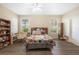 Well-lit bedroom with a large bed, neutral walls, a ceiling fan, and wood floors for a serene atmosphere at 16627 Rockwell Heights Ln, Clermont, FL 34711