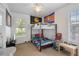 Bedroom with a bunk bed, ceiling fan, carpet, and natural light from a window at 16627 Rockwell Heights Ln, Clermont, FL 34711