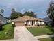 Charming single-story home boasts a manicured front lawn, mature landscaping, and a two-car garage at 16627 Rockwell Heights Ln, Clermont, FL 34711