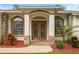 Inviting front entrance featuring a decorative double door, stone accents, and mature landscaping at 16627 Rockwell Heights Ln, Clermont, FL 34711