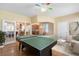 Open game room with a ping pong table, seating, and views to the breakfast bar, kitchen and dining areas at 16627 Rockwell Heights Ln, Clermont, FL 34711