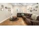 Open-concept living room with hardwood flooring, a brown leather couch, and light-colored walls with Gathering photos at 16627 Rockwell Heights Ln, Clermont, FL 34711