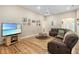 Spacious living room featuring hardwood floors, a ceiling fan, and comfortable seating with a brown leather sofa at 16627 Rockwell Heights Ln, Clermont, FL 34711