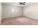 Cozy bedroom featuring plush carpeting, a ceiling fan, and a window providing plenty of natural light at 17764 Se 95Th Ct, Summerfield, FL 34491