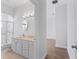 Bright bathroom with glass shower enclosure, white vanity, and a view into the next room at 17899 Se 115Th Cir, Summerfield, FL 34491