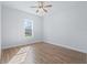 Bright bedroom featuring a window, wood-look flooring, white walls, and classic ceiling fan at 17899 Se 115Th Cir, Summerfield, FL 34491