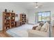 Open living room with hardwood floors, ceiling fan, built-in bookshelves and view to the exterior golf course at 17899 Se 115Th Cir, Summerfield, FL 34491