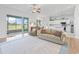 Inviting living room featuring a ceiling fan, sliding glass doors, and an open layout leading into the kitchen at 17899 Se 115Th Cir, Summerfield, FL 34491