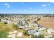 Wide aerial view of a neighborhood with lush green spaces, golf course and clear blue skies above at 1840 Madero Dr, The Villages, FL 32159