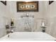 Modern bathroom featuring a soaking tub with gray tile surround, decorative accents, and built-in shelving at 1840 Madero Dr, The Villages, FL 32159