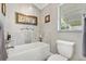 Modern bathroom featuring a soaking tub with gray tile surround, decorative accents, and toilet at 1840 Madero Dr, The Villages, FL 32159