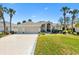 Charming home featuring a well-manicured lawn, three-car garage, and inviting front entrance at 1840 Madero Dr, The Villages, FL 32159