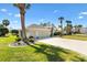 Well-maintained home featuring a three-car garage, palm trees, and lush landscaping at 1840 Madero Dr, The Villages, FL 32159