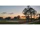 Scenic view of the golf course at sunset with mature trees and manicured greens at 1840 Madero Dr, The Villages, FL 32159