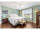 Cozy bedroom with a tufted headboard, wood floors, and large bright window at 1914 Antonia Pl, The Villages, FL 32159