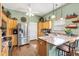 Kitchen with stainless steel appliances, wood cabinets, granite countertops, and pendant lights at 1914 Antonia Pl, The Villages, FL 32159