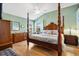 Inviting main bedroom features a four-poster bed, wood floors, and plenty of natural light at 1914 Antonia Pl, The Villages, FL 32159