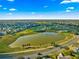 Aerial view of neighborhood featuring a golf course and scenic lake at 2010 Harston Trl, The Villages, FL 32162