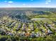 Aerial view of a residential neighborhood with a golf course in the distance at 2010 Harston Trl, The Villages, FL 32162