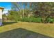 Well-kept backyard with a green lawn and mature landscaping, creating a private oasis at 2010 Harston Trl, The Villages, FL 32162