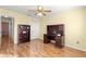 Bedroom with hardwood floors, a desk with a hutch, a ceiling fan, and a closet at 2010 Harston Trl, The Villages, FL 32162