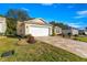 Exterior shot of the house, including a two-car garage and manicured lawn at 2010 Harston Trl, The Villages, FL 32162