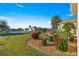 Landscaped front yard with mature trees, flowering bushes, and well-maintained lawn at 2010 Harston Trl, The Villages, FL 32162