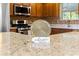 Close-up of kitchen island with stainless steel appliances in background at 2010 Harston Trl, The Villages, FL 32162