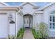 Elegant home entrance showcasing a decorative glass front door and manicured greenery at 2022 Abordale Ln, The Villages, FL 32162