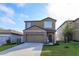 Two-story home with stone accents, a well-maintained lawn, and a two-car garage at 2024 Hemingway Cir, Groveland, FL 34736