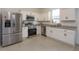 Bright kitchen featuring stainless steel appliances, granite countertops, and white cabinets at 2024 Hemingway Cir, Groveland, FL 34736