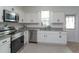 Bright kitchen featuring white cabinetry, stainless steel appliances, and granite countertops at 2024 Hemingway Cir, Groveland, FL 34736