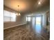 Spacious living area featuring tile flooring, a modern chandelier, and sliding glass doors to the outside at 2036 Sunshine Peak Dr, Minneola, FL 34715