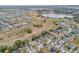 Aerial view of a residential community near a tranquil lake and open fields, offering a serene living environment at 235 Pima Trl, Groveland, FL 34736